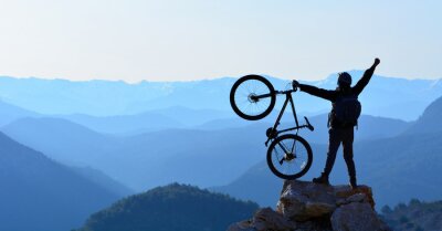 Obraz Człowiek z rowerem na szczycie